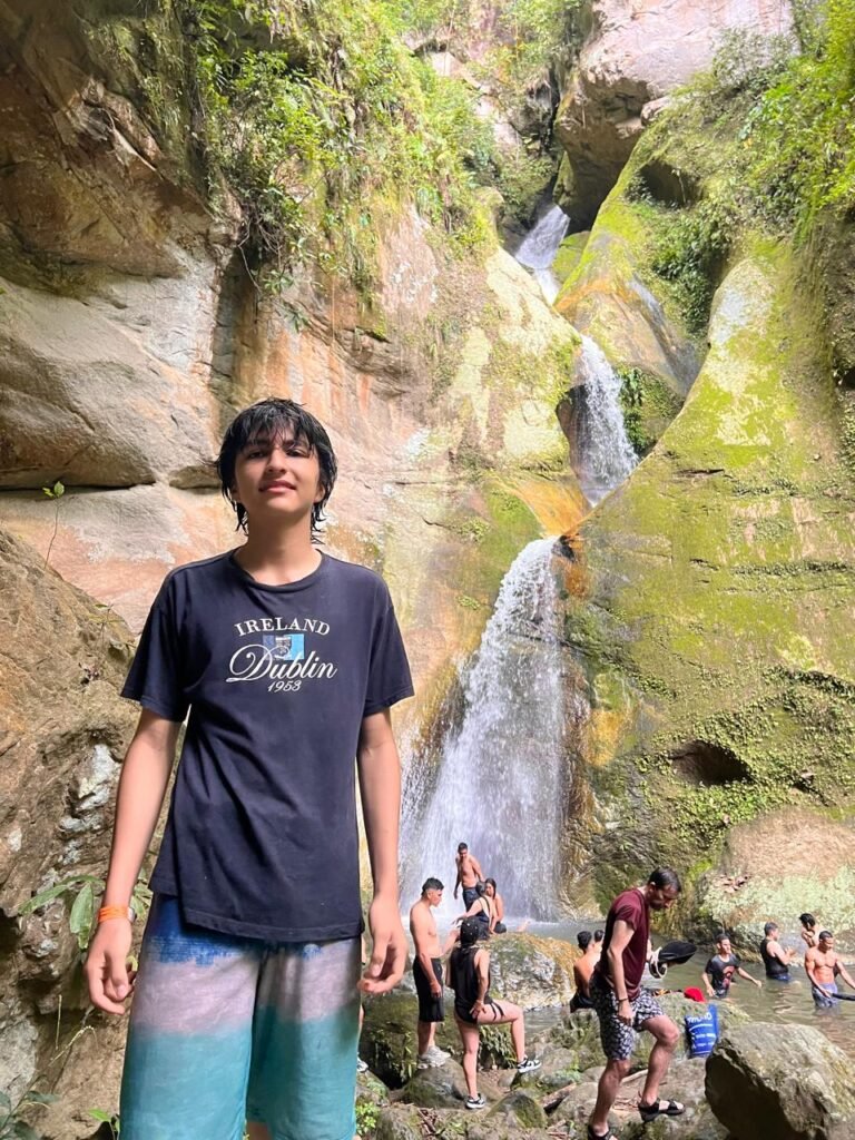 foto de niño y grupo en cascada disfrutando el lugar